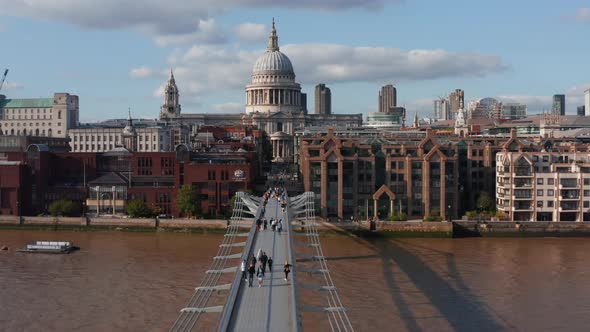 People Walking on Millennium Footbridge Over River Thames