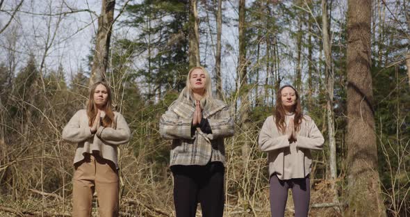 three girls meditate in nature breathe synchronously, inhale exhale