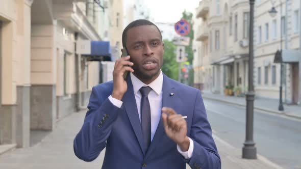 Walking African Businessman Talking on Phone