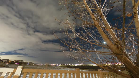 Night time time lapse of clouds, the setting moon, rotating stars and airplane trails in the winter