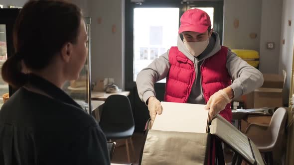 Delivery Man Packing Orders in Cafe