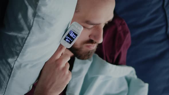 Vertical Video Close Up of Ill Man Sleeping on Sofa with Oximeter on Finger