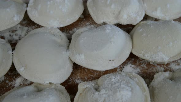 Rows of Frozen Raw Pelmeni Dumplings Stuffed with Mince Meat on Cutting Board