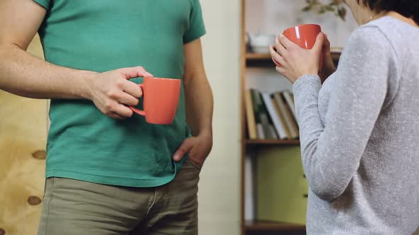 Couple in Love Talking About Something, Laughing and Drinking Coffee