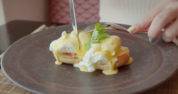 Extreme Closeup Shot Knife and Fork in Woman Hands with Bright Manicure Cut Pouched Egg Girl with a