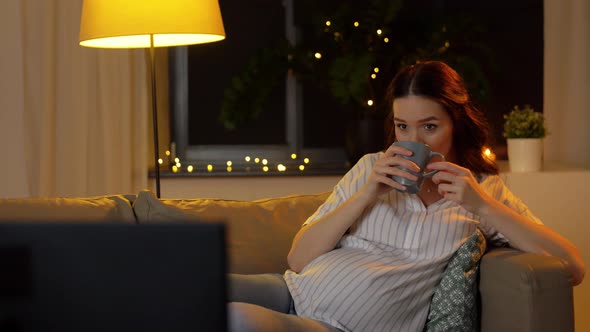 Pregnant Woman Watching Tv and Drinking Tea