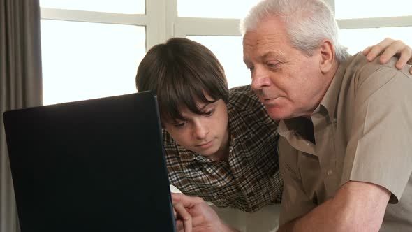 Little Boy Helping His Grandpa with Laptop