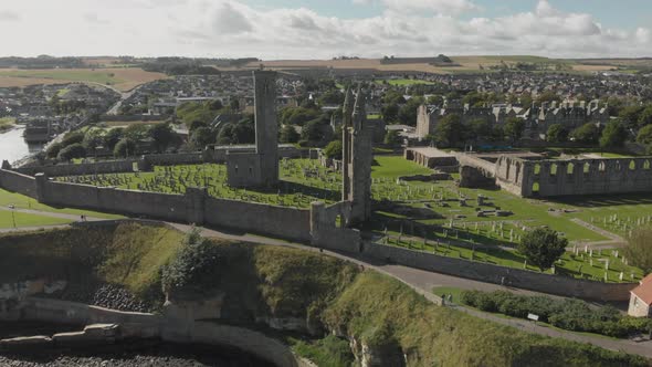 Aerial drone view of St Andrews Cathedral and cemetery grounds. ESTABLISHING, RISING, TILT-DOWN. 4K