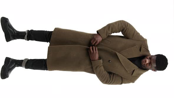 Confident Elegant Middleaged Black Man Standing and Buttoning His Light Brown Winter Coat