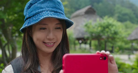 Woman use of mobile phone to take photo in Japanese wooden house 