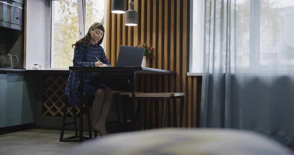 Portrait of a Young Girl in Headphones Talking in Front of a Laptop Screen