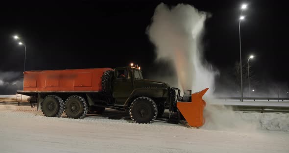 A Grader Clears Snow On A Road Outside The City 