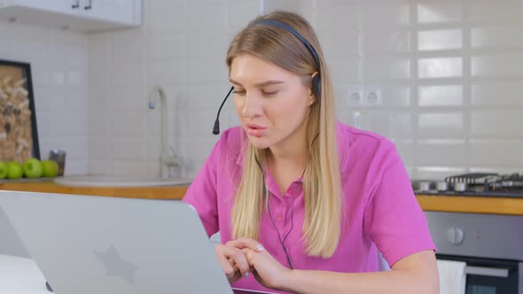 Cheerful online helpdesk operator speaking with client wearing headset with microphone in 4k video