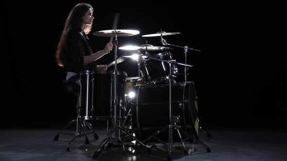 Drummer Girl Starts Playing Energetic Music, She Smiles. Black Background. Slow Motion