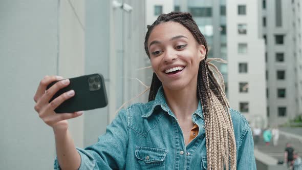 A Lovely Smiling Young Mixedrace Woman is Talking to Someone with a Video Chat or Blogging Concept