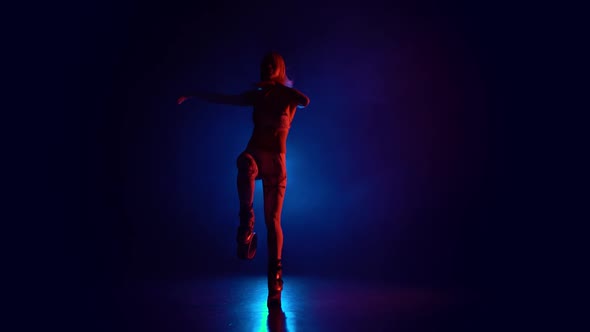 Athletic Girl Jumping in Kangoo Jumps Shoes Against Blue Spotlight