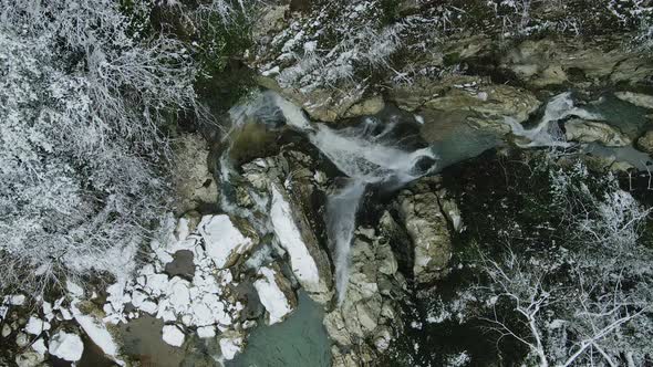 Waterfall Flowing From White Rocks Into a Lake in the Forest