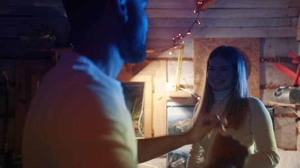 Young Couple Dancing and Flirting with Flashing Lights