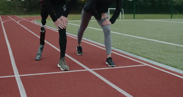 Crop View of Disabled Man and Sports Woman Taking Position on Marks and Start Running