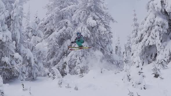 A man skiing down a snow-covered mountain in the winter