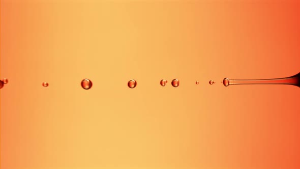 Super Slow Motion Drops Pomegranate Juice on an Orange Background