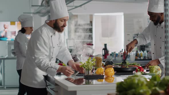 Professional Cook Adding Rosemary Plant Leaves in Kitchen