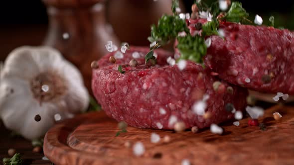 Super Slowmotion Footage of Strewing Salt and Herbs at Fresh Raw Beef Meat Burger 1000Fps