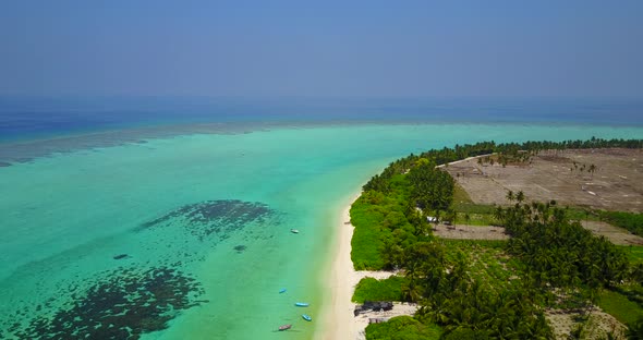 Wide aerial island view of a white sand paradise beach and aqua turquoise water background in high r