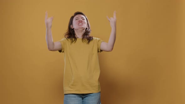 Rebel Woman with Positive Attitude Doing Rock and Roll Hand Gesture with Tongue Out Wanting to Party