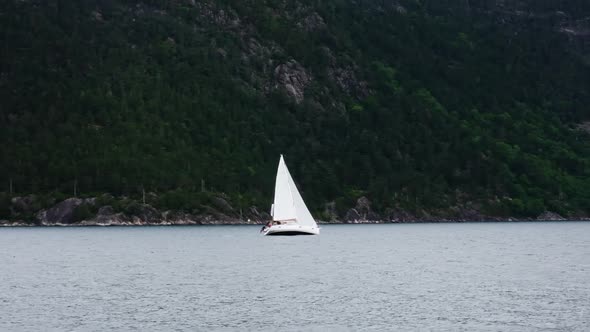 Sea with Yacht at the Foot of the Fjord Mountains