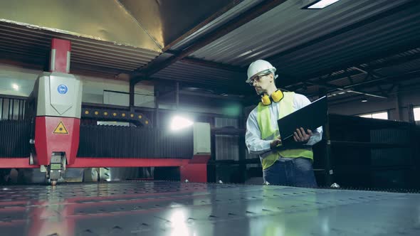 Laser Cutter Is Being Watched By a Factory Technician