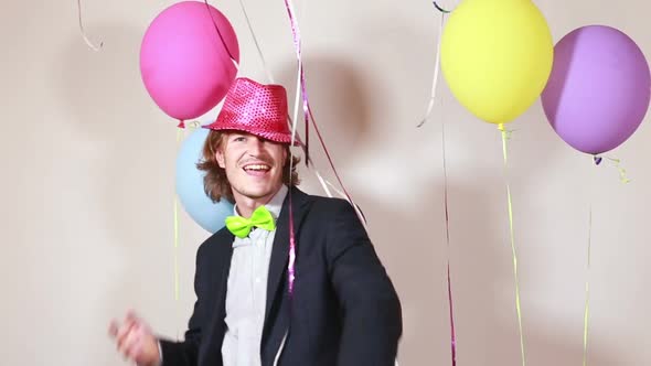 Attractive man wearing pink hat and dancing funny