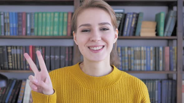 Victory Sign By Positive Young Woman