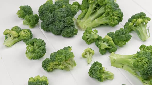 Broccoli Scattered on White Wooden Table