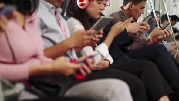 Young People Using Mobile Phone in Public Underground Train