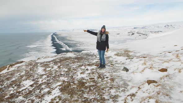 Young Woman Tourist Enjoying the View at the Top of the Cliff Around Reynisfjara Beach and Dyrholaey