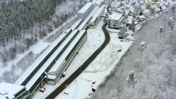 Drifting car in the winter at a frozen parking lot, filmed from above by a drone