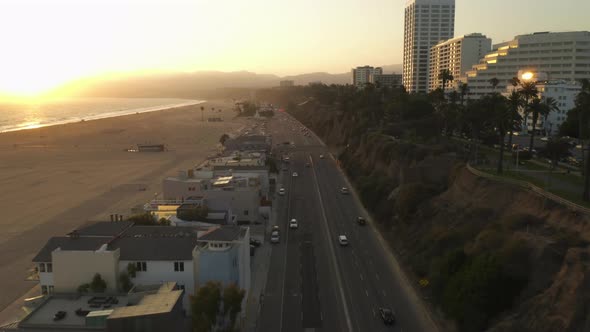 Pacific Coast Highway with Light Traffic and Ocean View at Beautiful Golden Hour Sunset Waves Aerial