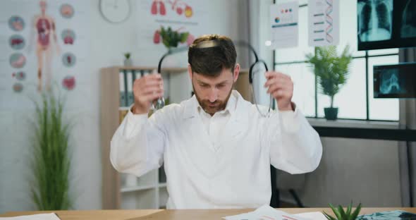 Doctor in white Coat with Stethoscope which Sitting in front of Camera