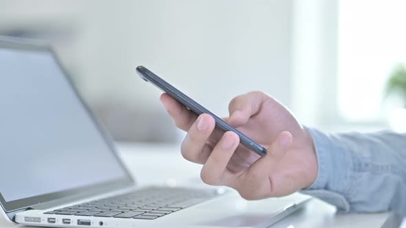 Close Up of Hand Using Smartphone in Office