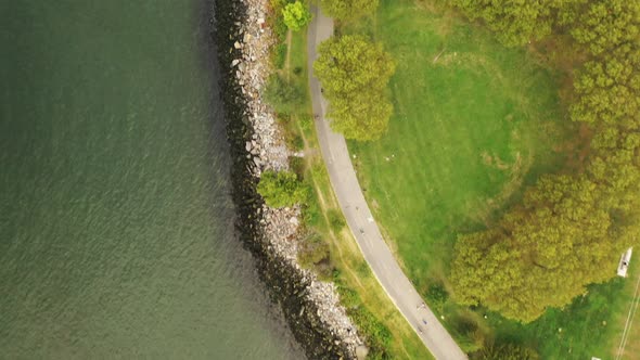 A top down shot over the stoney shores of the East River near the Throgs Neck Bridge. It is a cloudy