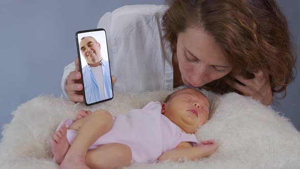 Young Mother and Baby Having Video Chat. Woman Using Smartphone Waving at Little Daughter Enjoying