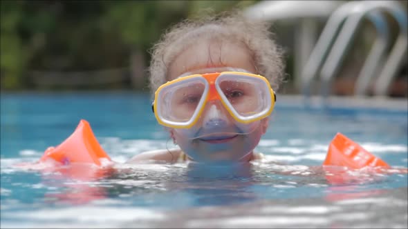 Portrait Little Girl in an Underwater Mask Floating in an Outdoor pool.Active Rest in the Water Park