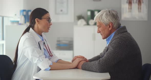 Portrait of Female Doctor Talking to Upset Aged Patient Discussing Diagnosis and Treatment