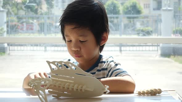 Cute Asian Child  Builds A Toy Of Wood Slow Motion