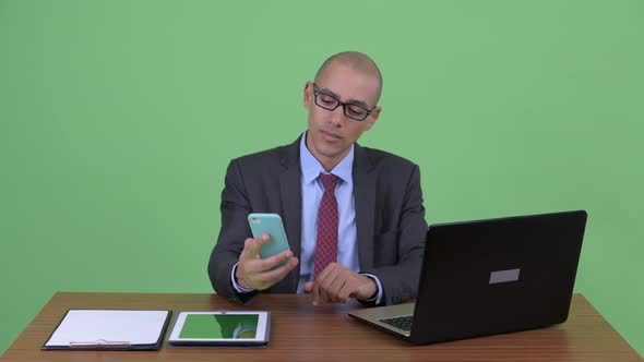 Happy Bald Multi Ethnic Businessman Video Calling at Work