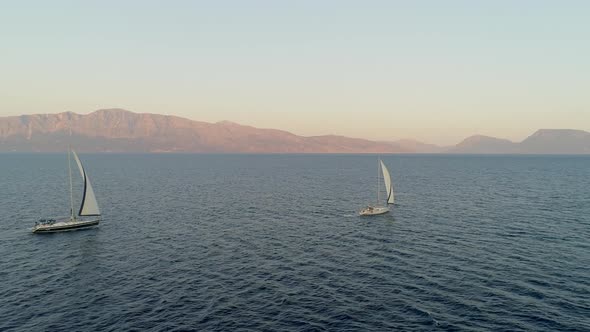 Aerial view of two sailboat anchored in the mediterranean sea, Vathi, Greece.