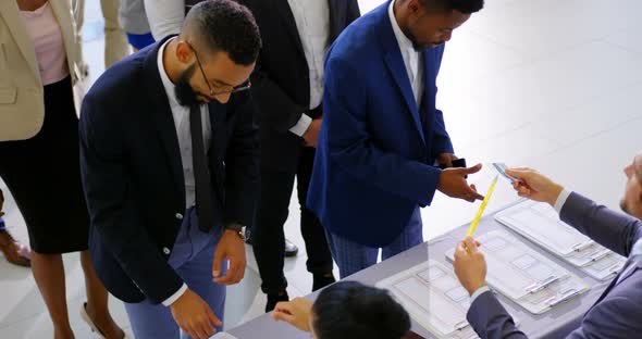 Business people checking in at conference registration table 4k