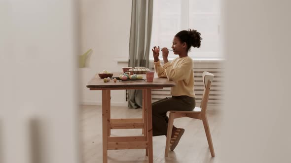 Girl Painting Eggs at Table