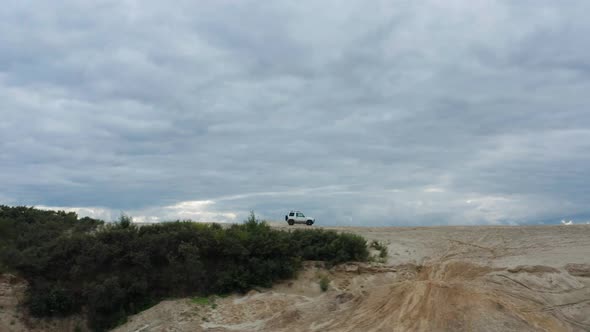 Aerial View of a Car Driving on Sand